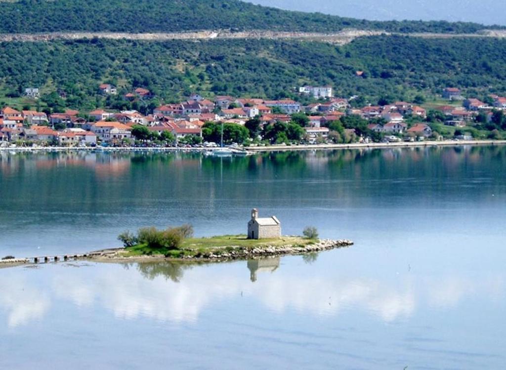 a person standing on an island in the middle of a lake at Apartmani Ante in Posedarje