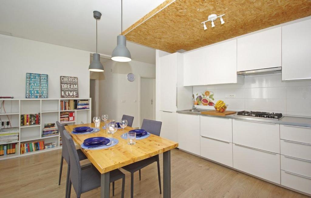 a kitchen with a wooden table and white cabinets at Apartment MIVA in Brela