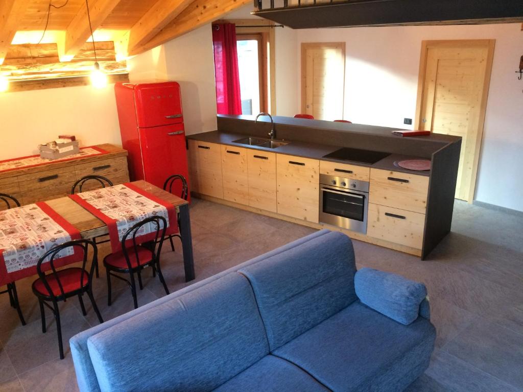 a living room with a blue couch and a kitchen at Pista Stelvio Loft Lumière in Bormio