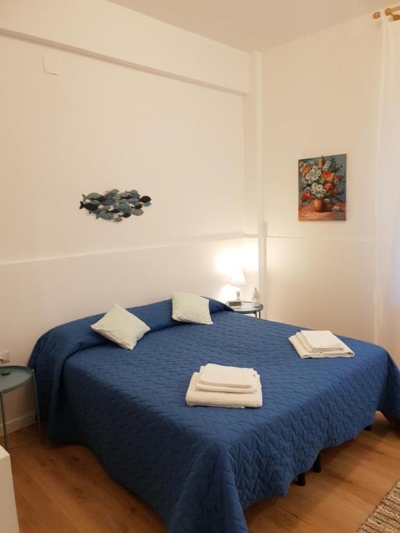 a bedroom with a blue bed with two towels on it at La casa di "Bella" in Milazzo