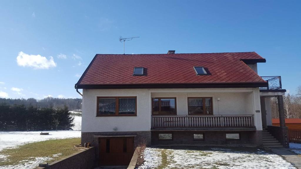 a house with a red roof with snow on the ground at Apartment Vcelakov in Včelákov