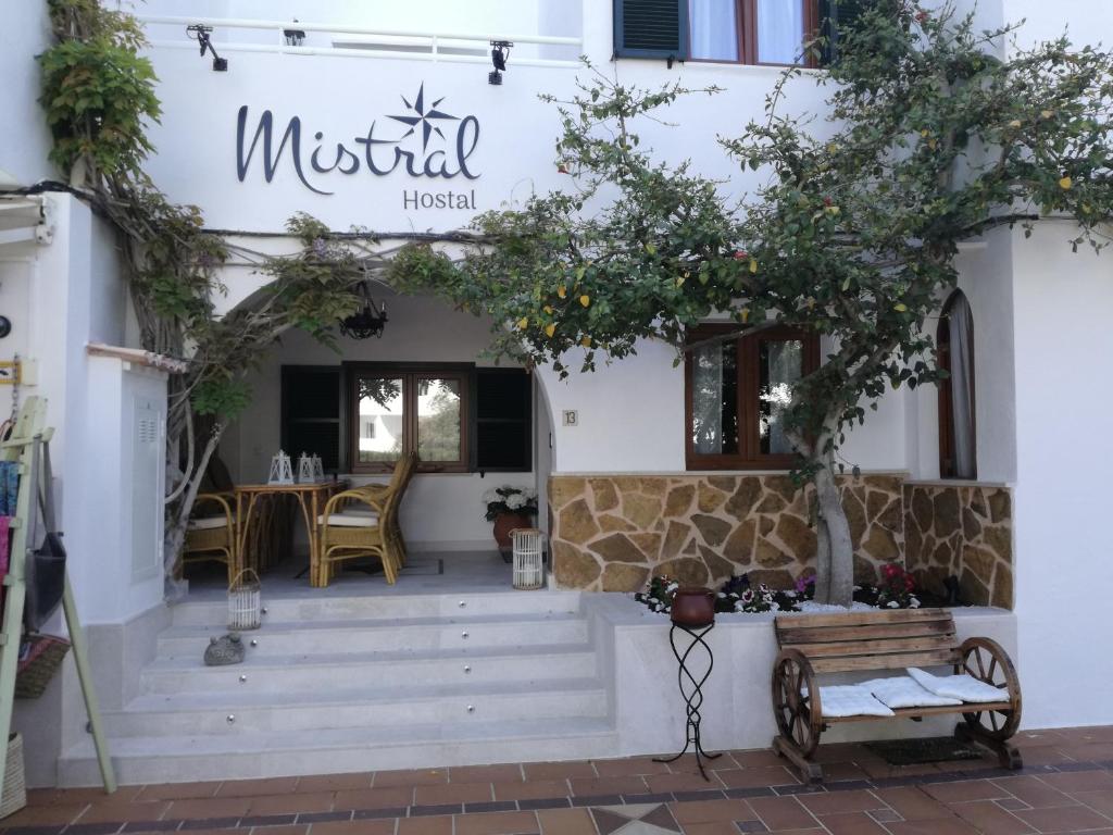 un restaurant avec banc devant un bâtiment dans l'établissement Boutique Hostal Mistral, à Cala d´Or