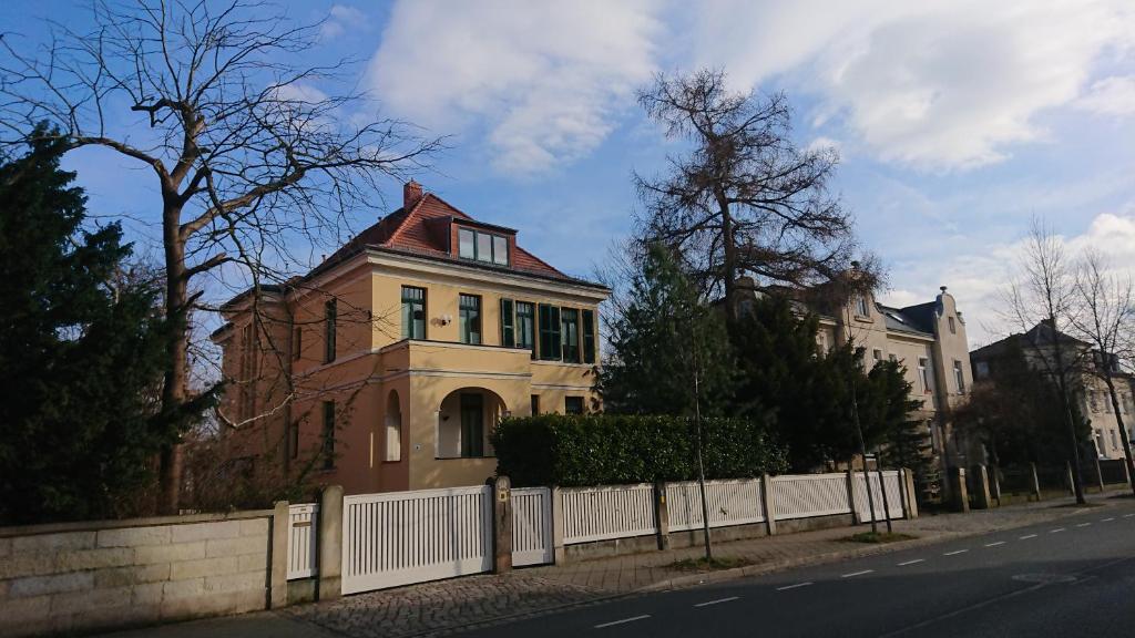 una casa sul lato di una strada con una recinzione di Altenberger Stadtvilla a Dresda