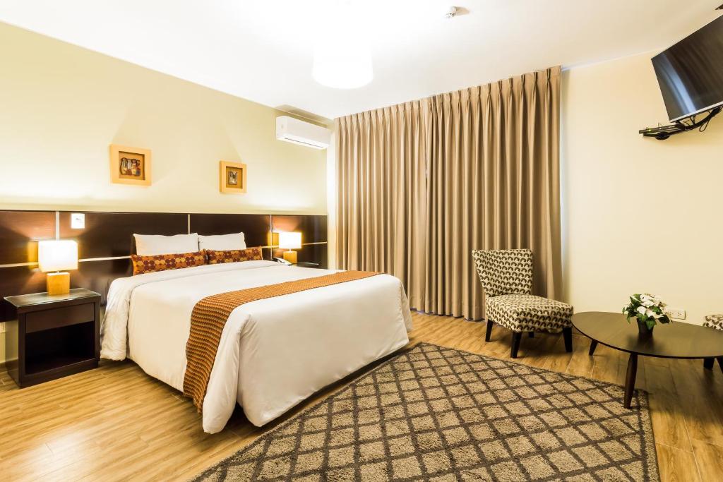 una camera d'albergo con letto e tavolo di Tambo Dos de Mayo a Lima