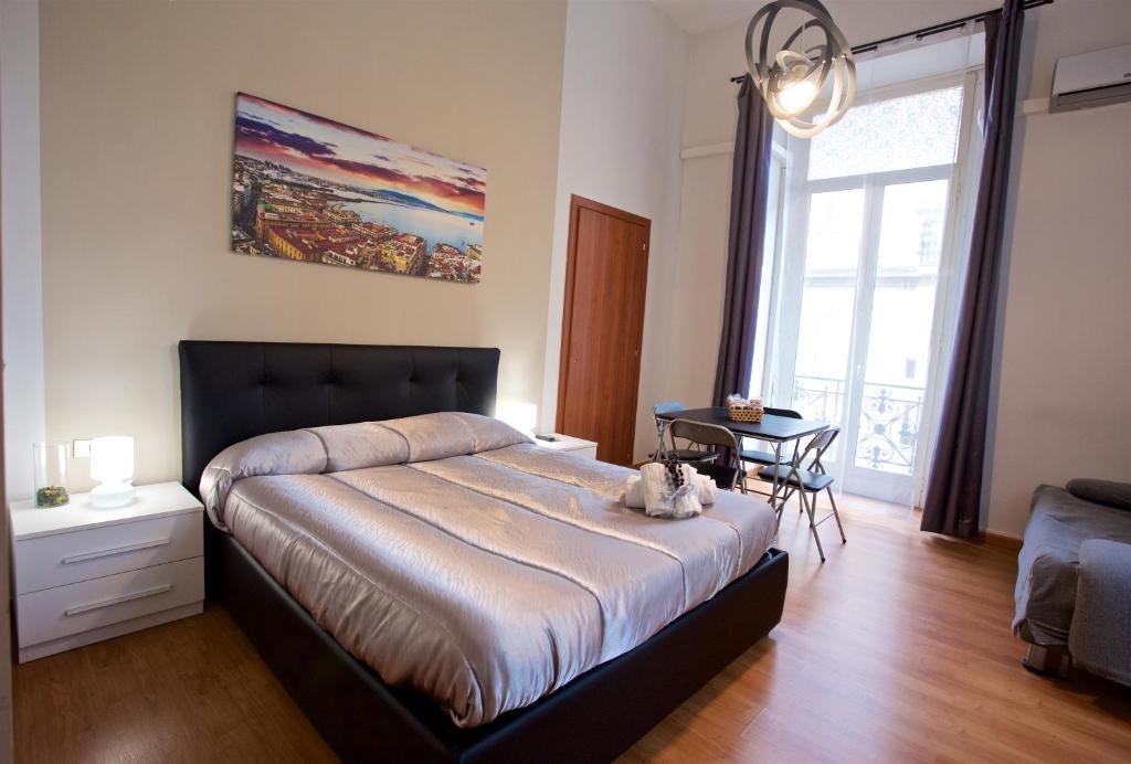 una camera da letto con un letto e un gatto seduto sopra di MetròNapoli a Napoli