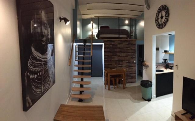 un salon avec un escalier en colimaçon et une horloge dans l'établissement Studio côté cour, à Antibes