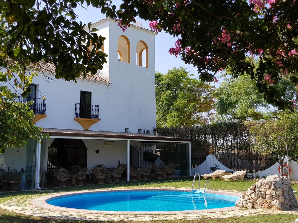 a house with a swimming pool in the yard at Hacienda el Santiscal in Arcos de la Frontera