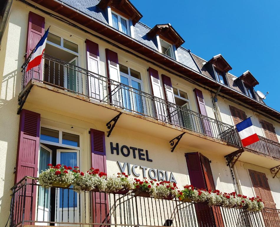 una señal de hotel en el lateral de un edificio en Hotel Victoria, en Saint-Pierre-de-Chartreuse