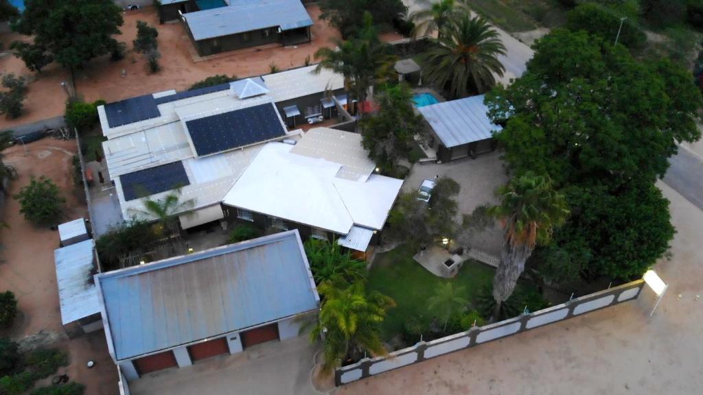 une vue sur une maison avec des arbres et des bâtiments dans l'établissement Bush Pillow Guest House, à Otjiwarongo