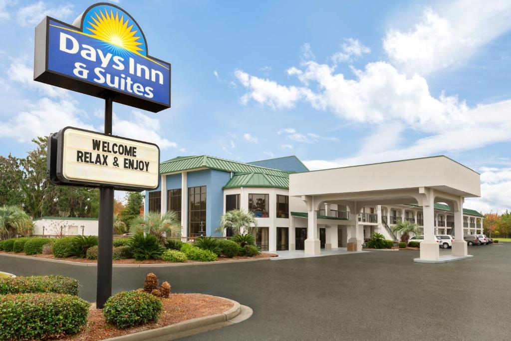 un cartello di fronte a una locanda e a suite di Days Inn & Suites by Wyndham Savannah Midtown a Savannah