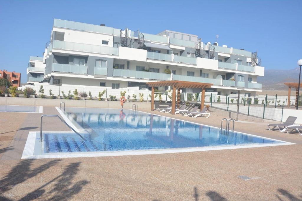 a large swimming pool in front of a building at New and cosy apartment - 4 min walk from the beach - La Tejita - El Medano in Granadilla de Abona