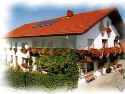 a building with a red roof with plants on it at Ferienwohnung Sonja in Prackenbach