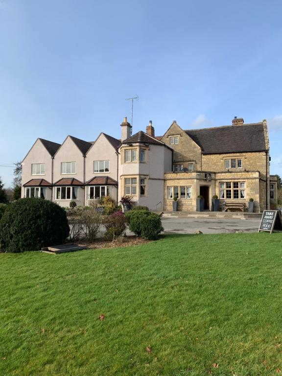 a large house with a lawn in front of it at Beckford Inn in Beckford