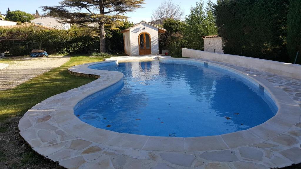 - une piscine dans une cour avec une petite chapelle dans l'établissement Maison au Paradou, à Paradou