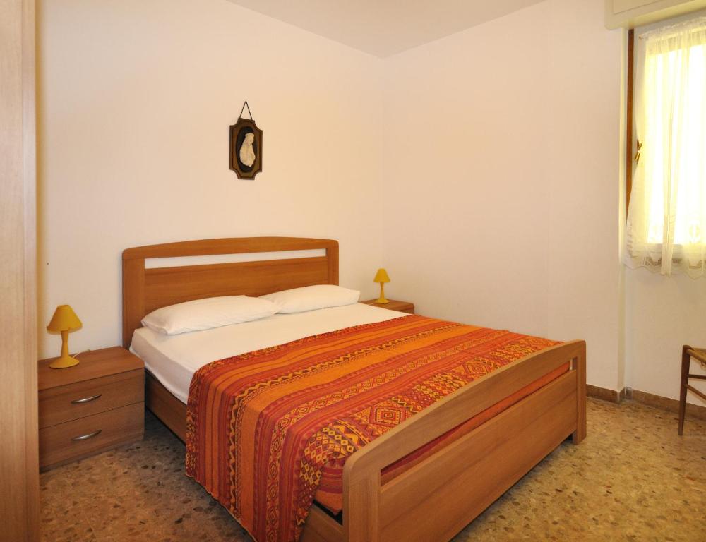 una camera con un letto e un orologio a muro di Condominio Aurora a Bibione