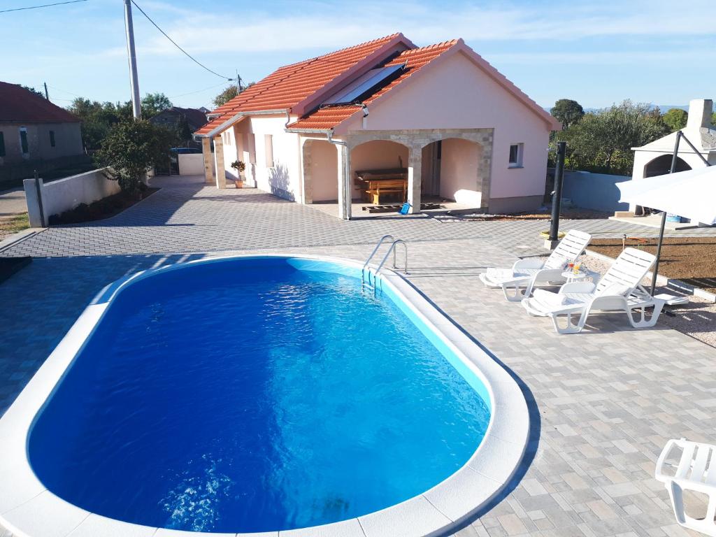 a swimming pool in front of a house at Samodol in Drinovci