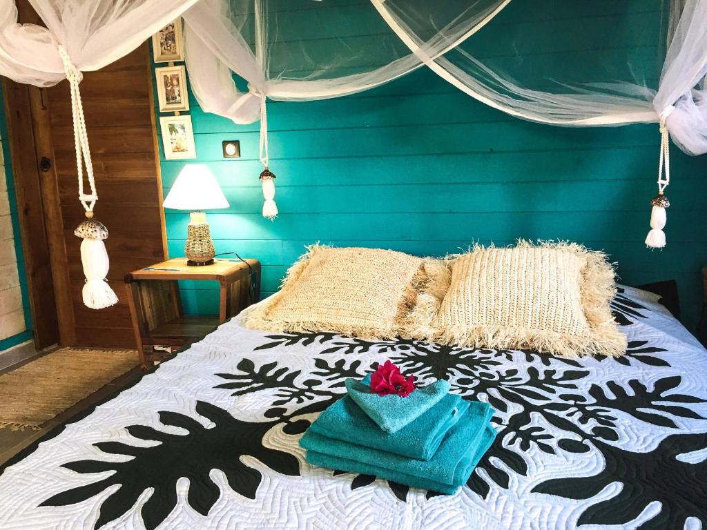 um quarto com uma cama com uma parede azul em The BlueBamboo em Le Moule