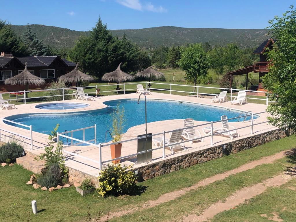 a large swimming pool with chairs in a yard at Cabañas El Trigal in Nono