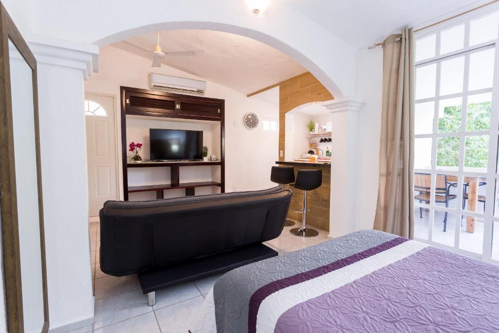 a bedroom with a bed and a flat screen tv at Quetzal Loft in Cancún