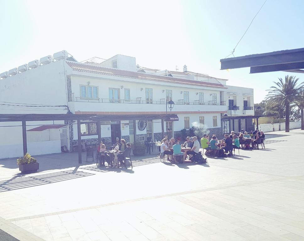 a group of people sitting in front of a building at Hotel Sonia Chipude in El Cercado