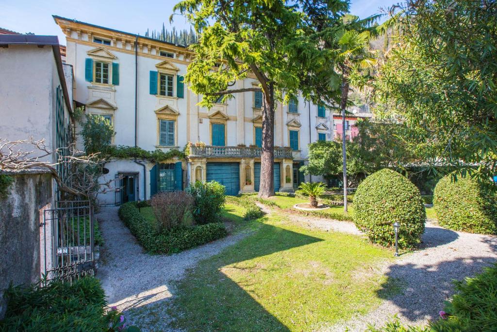 Una casa grande con un jardín enfrente. en Il Batti apartment water front and private beach, en Toscolano Maderno