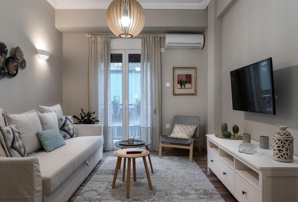 een woonkamer met een bank en een tv bij Αbsolute Athens VIII in Athene