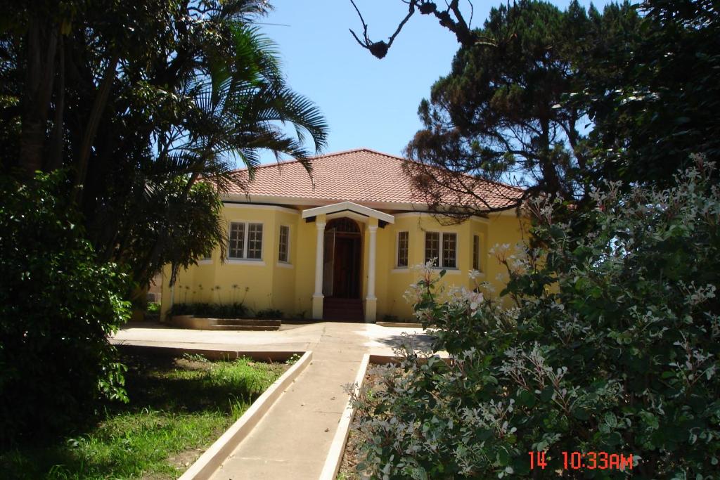 żółty dom z drogą przed nim w obiekcie The Crescent Guesthouses - BnB/Self Catering w mieście Durban