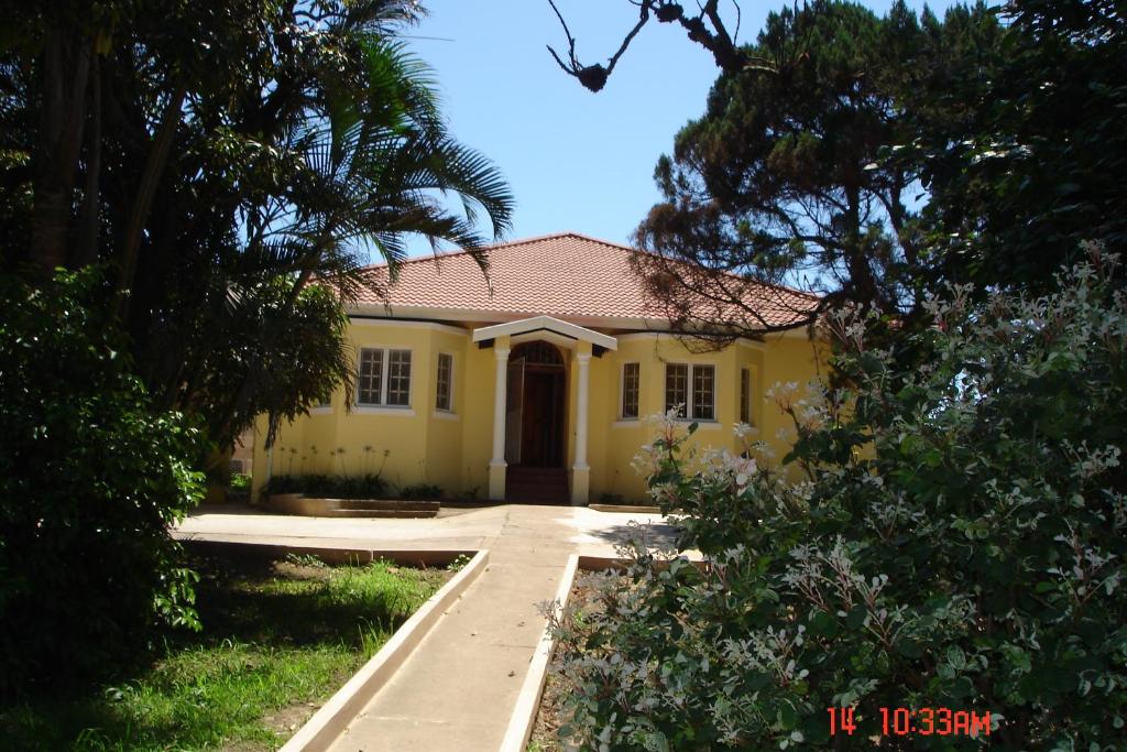 uma casa amarela com um caminho à sua frente em The Crescent Guesthouses - BnB/Self Catering em Durban