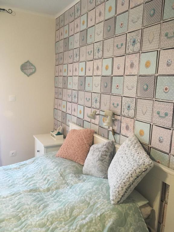 a bedroom with a bed and a tiled wall at Villa Casa Mia in Balatonlelle