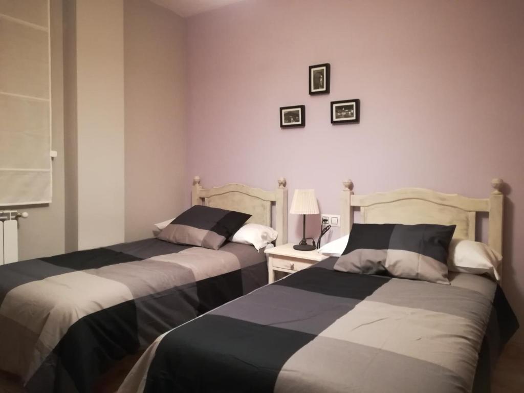 - une chambre avec deux lits et une table avec une lampe dans l'établissement Apartamento La Muralla de Teruel, à Teruel