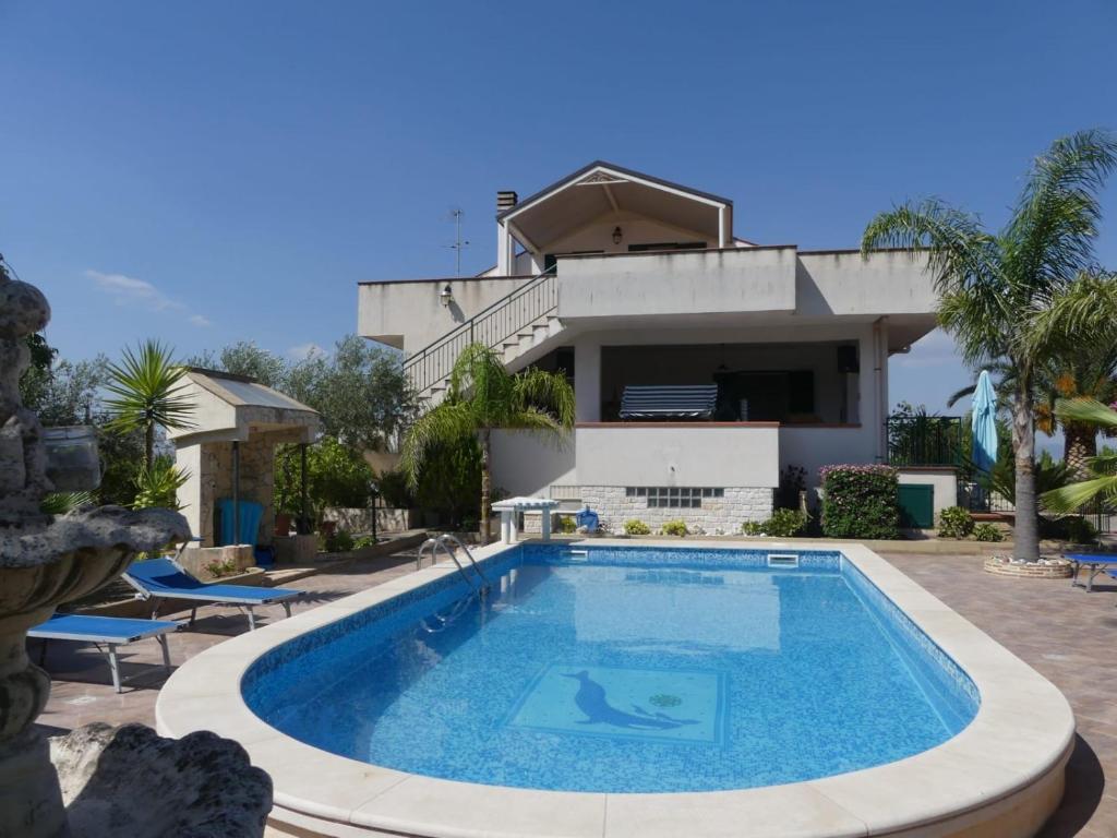 a swimming pool in front of a house at villa Giò in Racalmuto