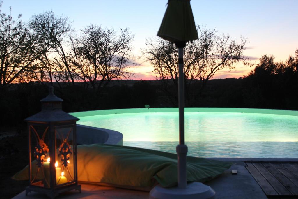 uma lanterna ao lado de uma piscina ao pôr-do-sol em Monte do Mato dos Homens na Vidigueira