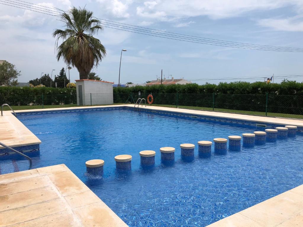 a swimming pool with a row of stools around it at Pis la rapita in Alcanar