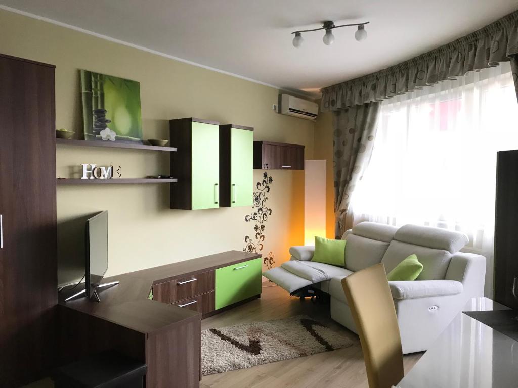 ein Wohnzimmer mit einem Sofa und einem TV in der Unterkunft Zen Apartment Oradea - FREE Parking in Oradea