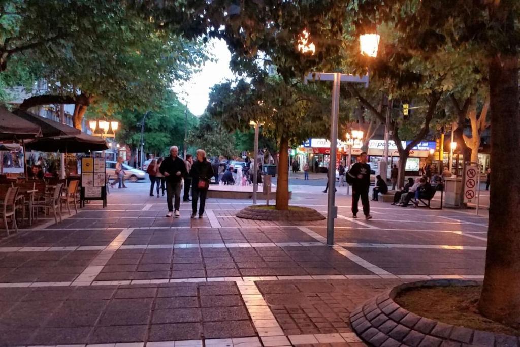 a group of people walking down a street at night at Peatonal Sarmiento in Mendoza