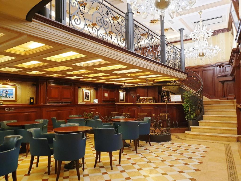 a restaurant with tables and chairs and a staircase at Royal San Marco Hotel in Venice