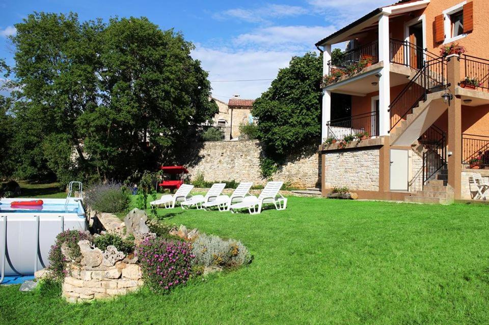 a group of chairs in a yard next to a building at Apartment Milan Istra in Režanci