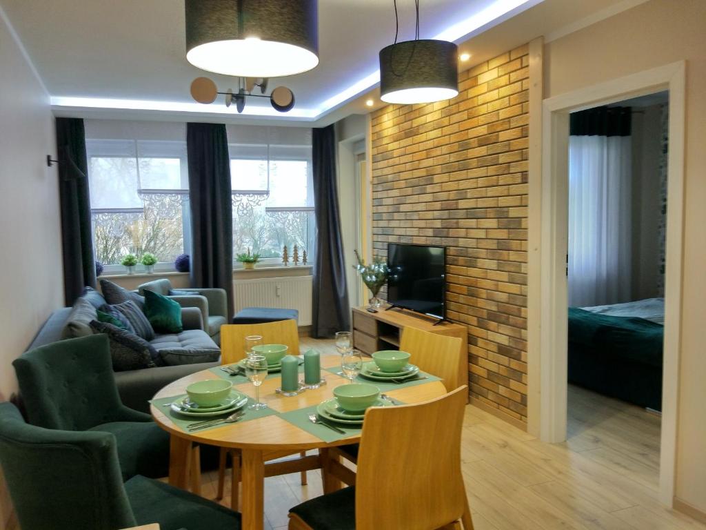 ein Esszimmer und ein Wohnzimmer mit einem Tisch und Stühlen in der Unterkunft Apartament Zielono Mi in Kołobrzeg