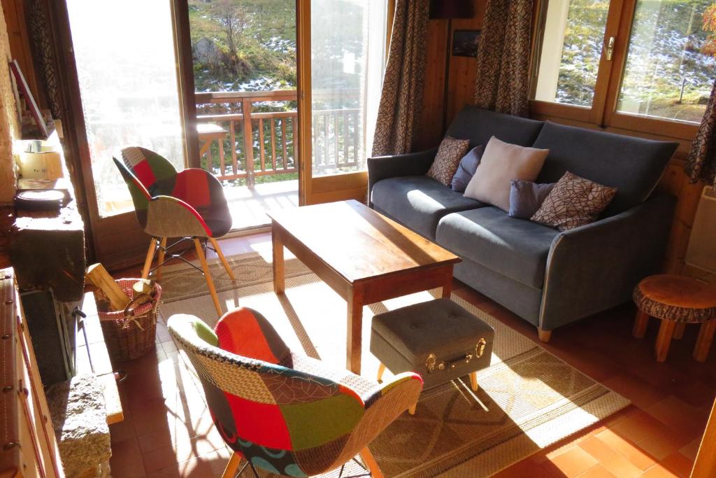 a living room with a couch and a table and chairs at Orée des pistes in Combloux