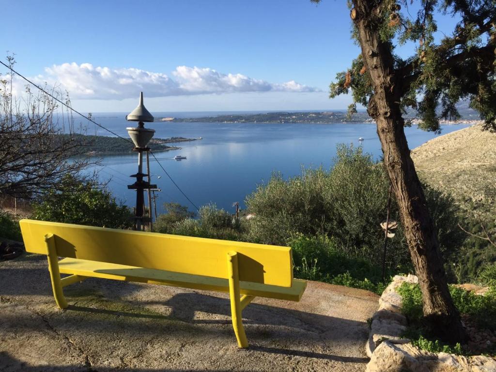 a yellow bench with a view of a lake at Art Studio Kefalonia in Dhavgáta