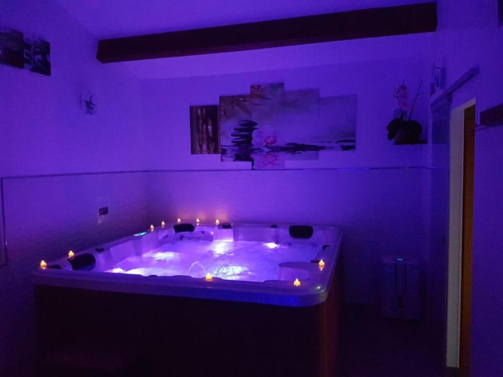 a purple room with a tub with lights in it at Chambre d&#39;hôtes source de la St Baume in Plan dʼAups
