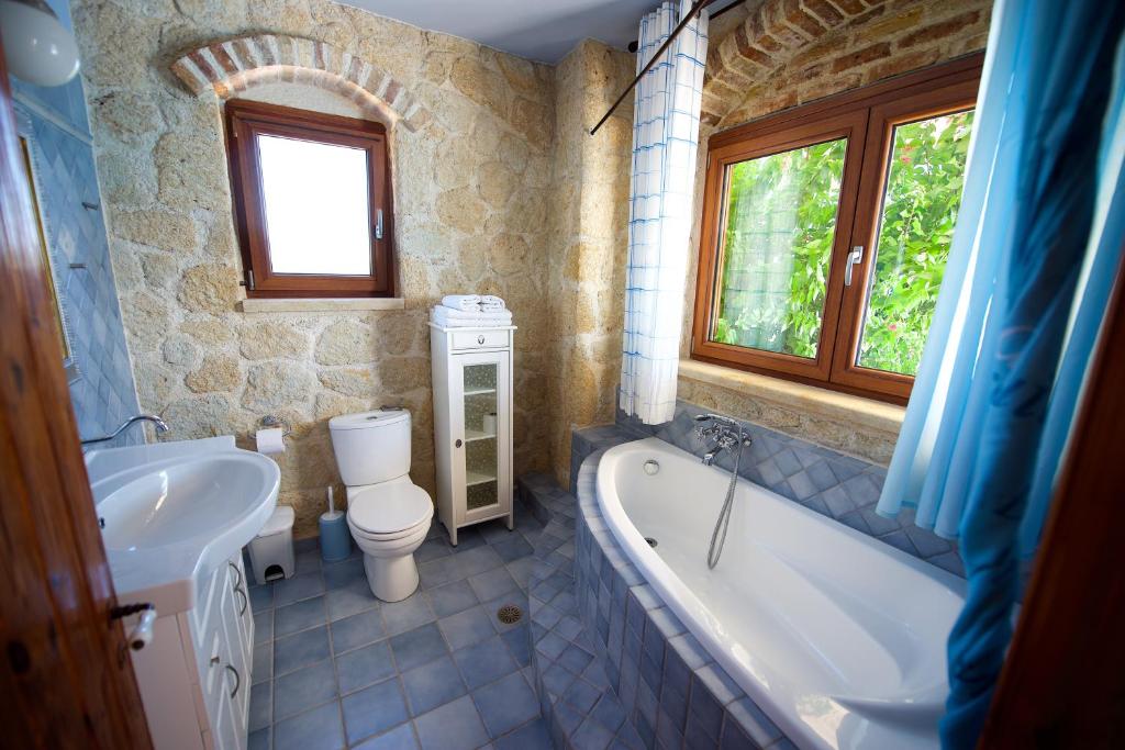 łazienka z wanną, toaletą i umywalką w obiekcie Villa Petrino w mieście Halikounas