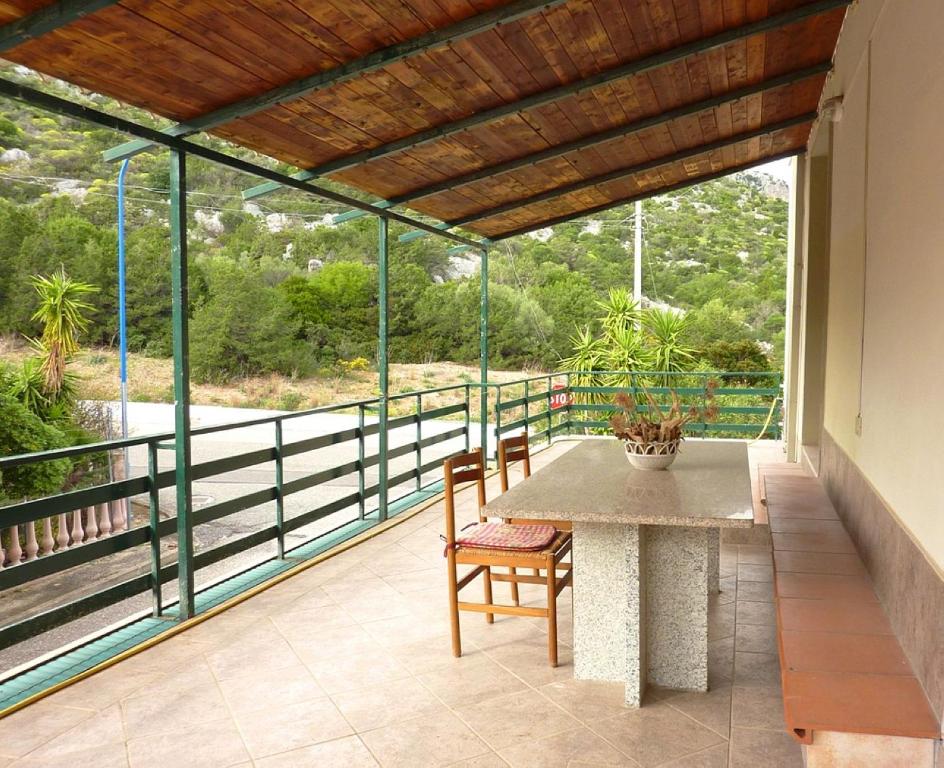 a patio with a table and chairs on a balcony at La bouganville Apartments in Cala Gonone