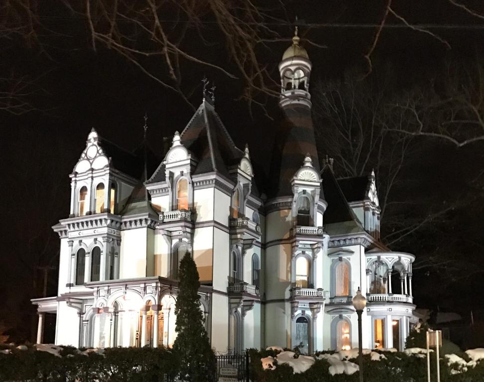 una gran casa blanca iluminada por la noche en Batcheller Mansion Inn, en Saratoga Springs