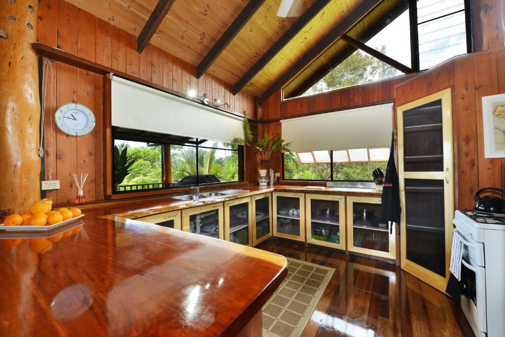 a kitchen with wooden walls and a large wooden table at Tea Tree Cottage in Diwan