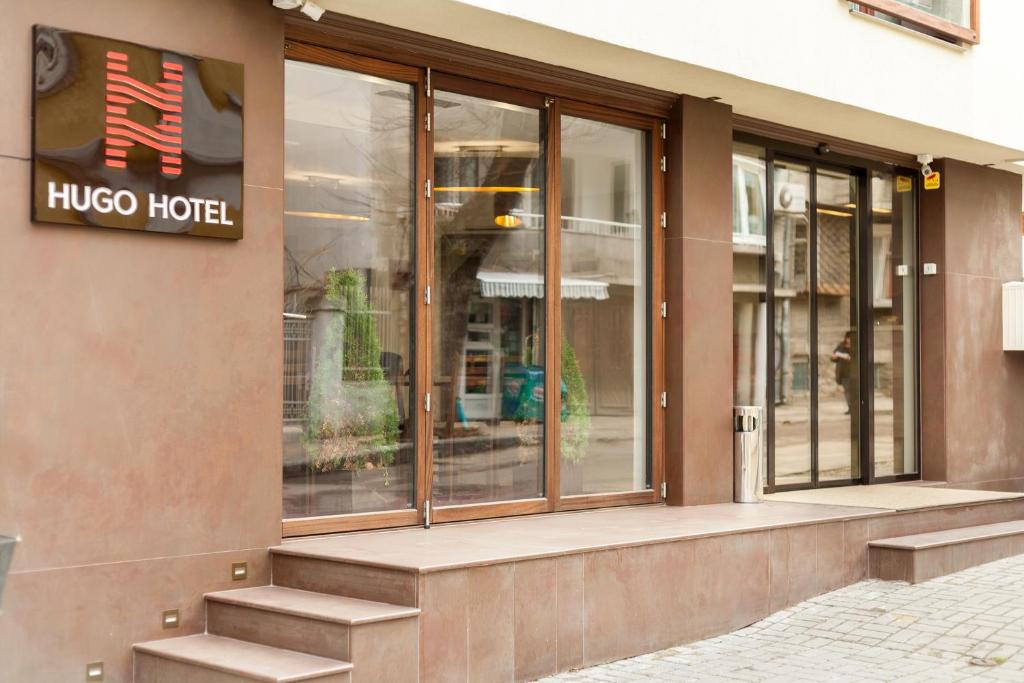 um edifício de hotel hico com uma placa na fachada em Hugo Hotel em Varna City
