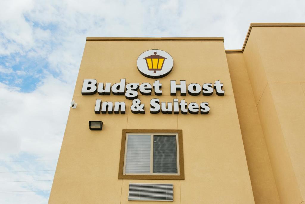 um edifício com uma estalagem de hambúrgueres e suites assinam nele em Budget Host Inn & Suites em Four Corners