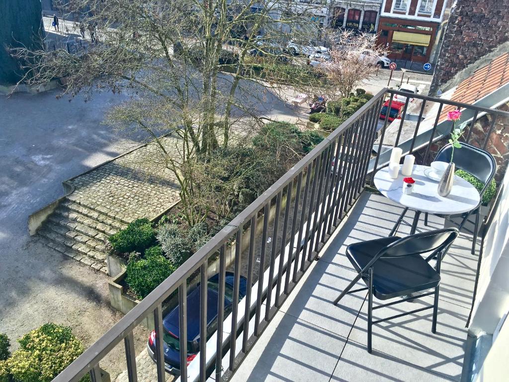 a balcony with a table and chairs on it at LITTLE PLAZA Appart'Hotel in Lille