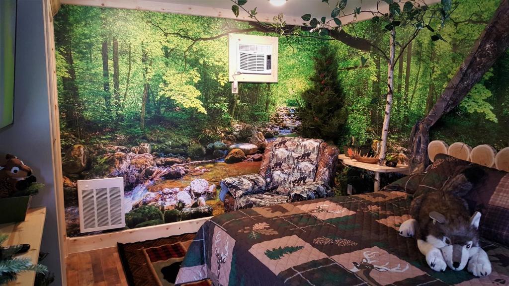 a bedroom with a painting of a forest at Bear Cove Inn in Saint Ignace
