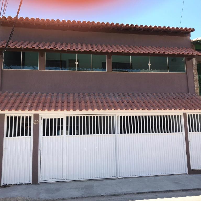 a white garage door with a red roof at CASA PÔR DO SOL 1 in Arraial do Cabo